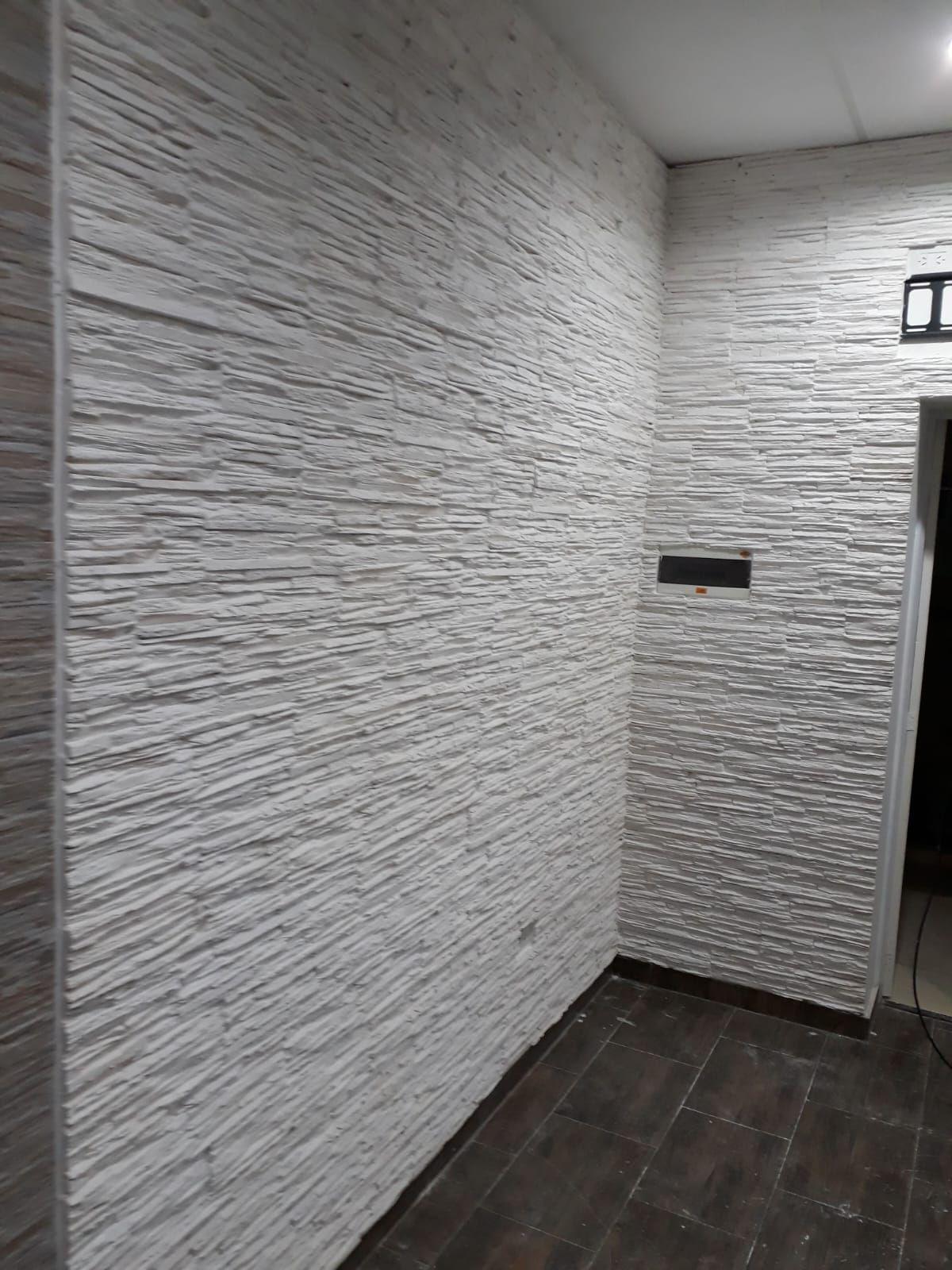 Pared revestida con placas antihumedad de textura símil piedra