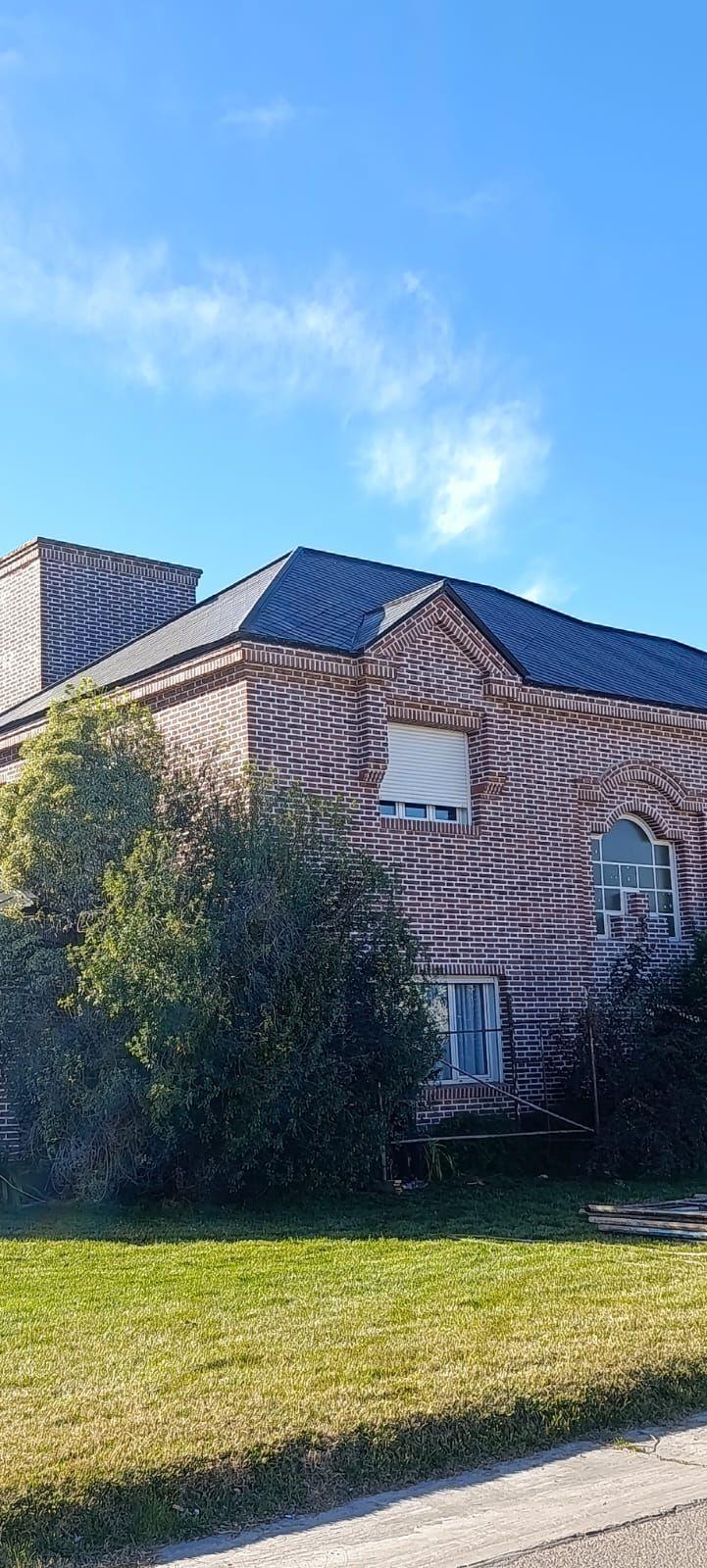 Casa de ladrillo con techo de tejas oscuras