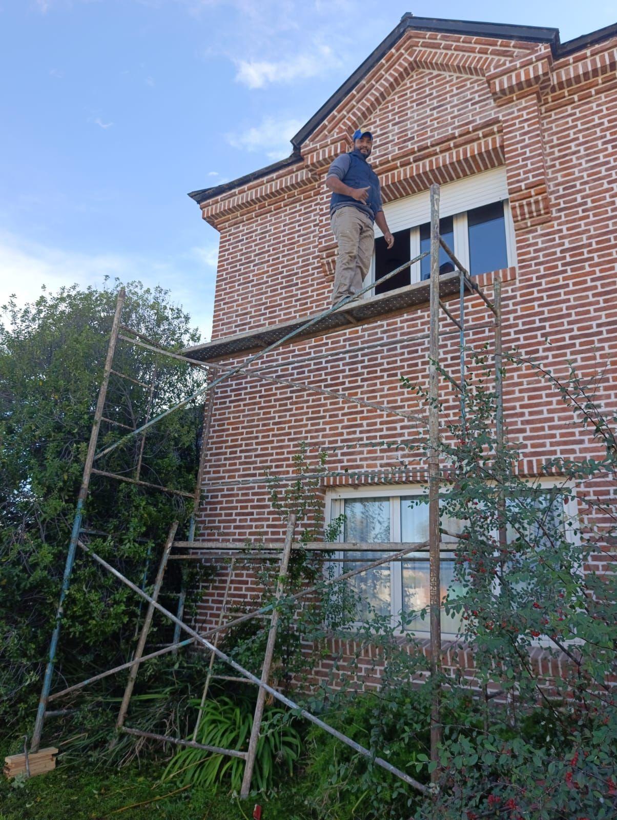 Trabajo en altura sobre andamio en una casa de ladrillo