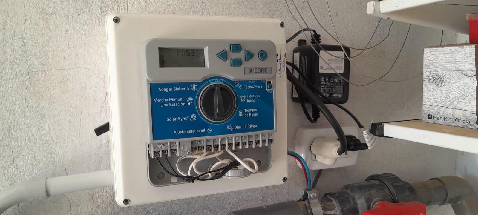 Programador de riego y conexiones eléctricas montados en la pared