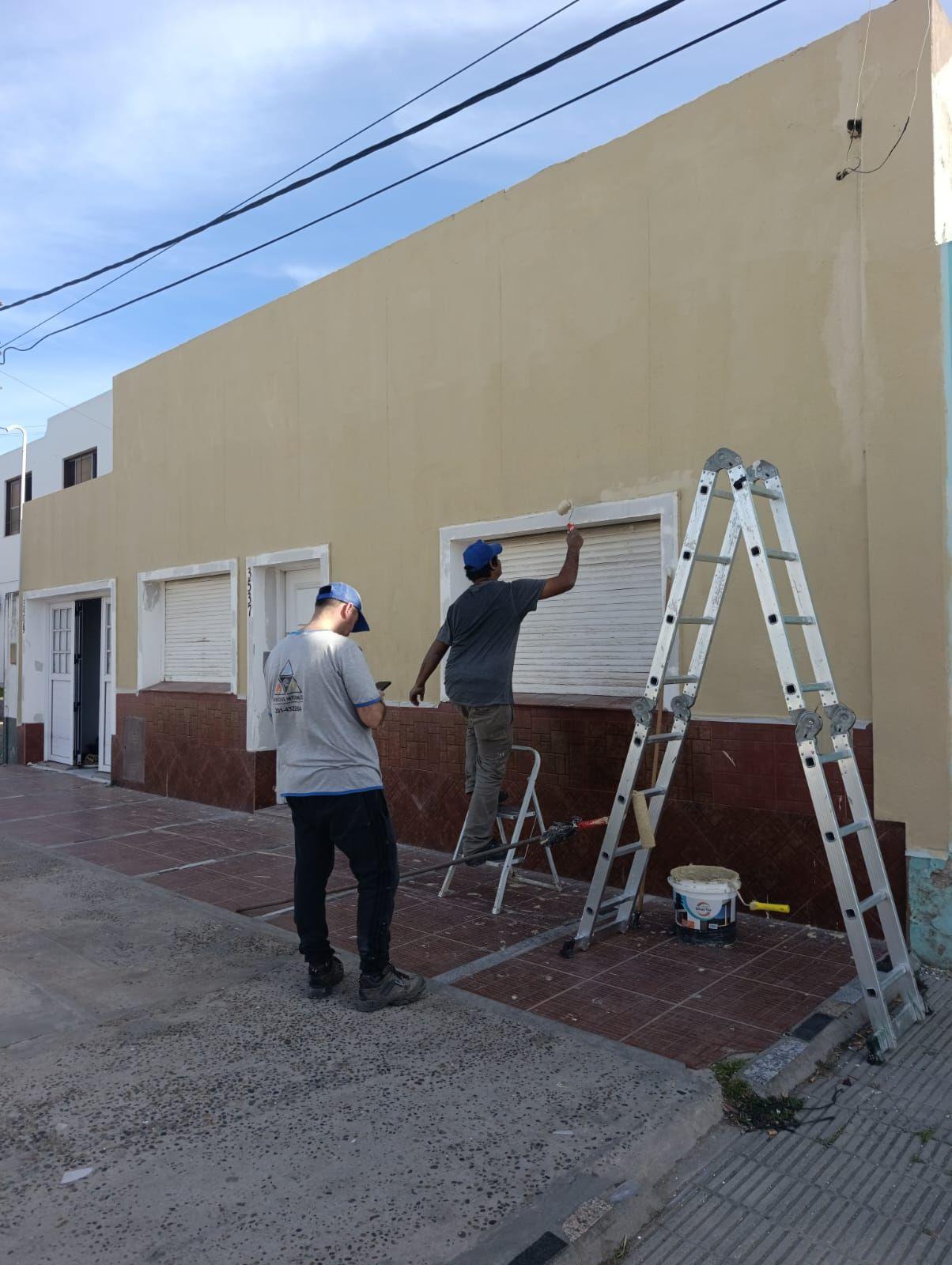 Pintores trabajando en el frente de una vivienda