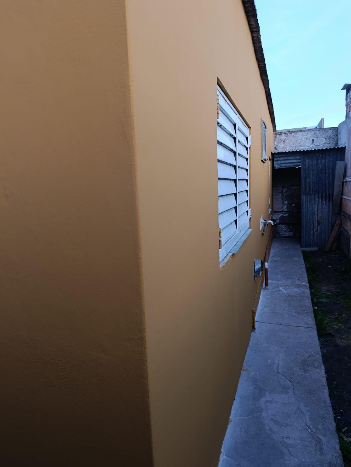 Pared exterior pintada junto a un pasillo lateral