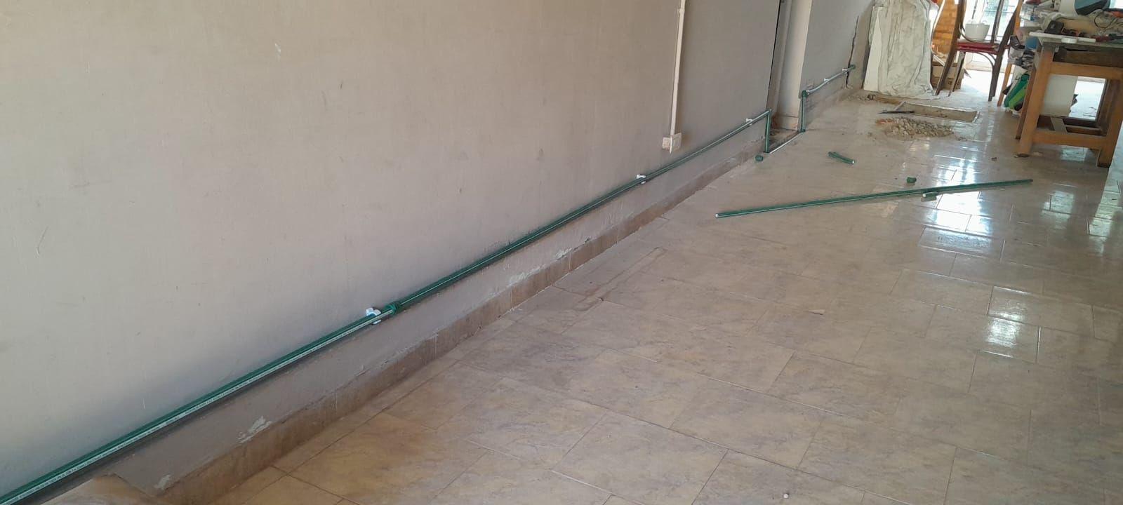Cañería de agua colocada junto al zócalo de un pasillo